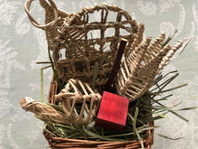 Load image into Gallery viewer, Willow basket with hay and a pine cube on a textured gray background
